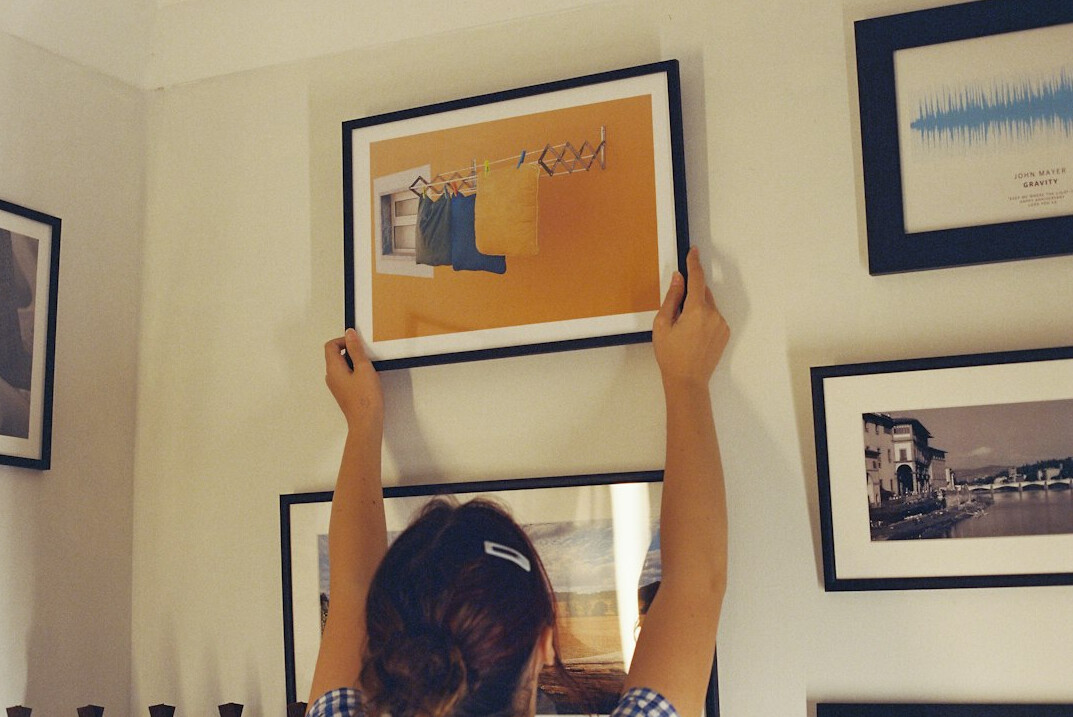 Framed prints being hung for a photography exhibition